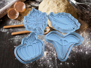 Herbstliche Keks-Ausstecher in Blau: Kürbis, Ahornblatt, Laubblatt und Samen für saisonale Backkunst.