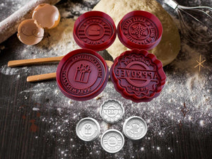 Festive cookie stamps with designs 'Santa's Post', 'Frohe Weihnachten', 'North Pole Approved', and 'Santa's Mail' on a baking setup.