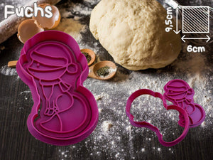 Purple fox cookie cutter for festive baking on a flour-dusted surface, surrounded by baking ingredients.