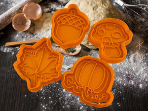 Herbst Keks-Ausstecher in Form von Ahornblatt, Eichel, Kürbis und Pilz auf einer bemehlten Arbeitsfläche.