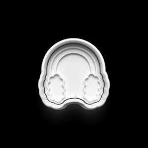 White ear muffs cookie cutter on a black background, perfect for winter-themed Christmas baking.