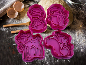 Festive winter animal cookie cutters - deer, polar bear, squirrel, and fox on a baking surface, ready for holiday fun.