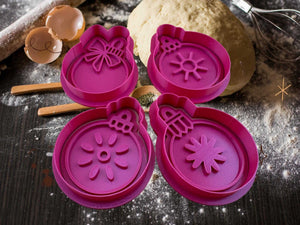 Festive pink Christmas ornament cookie cutters on flour-dusted table, ideal for elegant holiday baking with dough and marzipan.