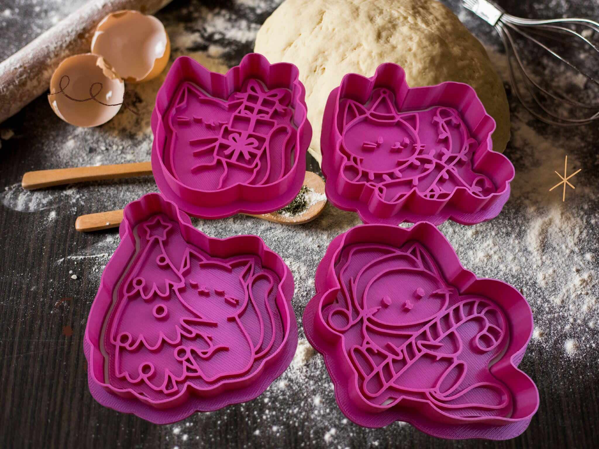 Four cute Christmas cat cookie cutters in pink, featuring a kitten with a gift, candy cane, Christmas tree, and Christmas lights.