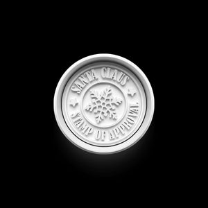 Festlicher Weihnachts-Keksstempel mit Schneeflockenmotiv und der Aufschrift "Santa Claus Stamp of Approval" auf schwarzem Hintergrund.