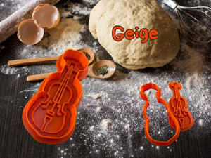 Geige cookie cutter with dough, flour, and eggs, ideal for music-themed baking and parties.