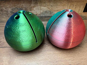 Zwei bunte Garnschalen in grün und rot mit praktischen Fadenausgängen für Strick- und Häkelprojekte.