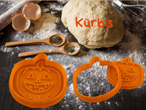 Halloween Kürbis Ausstecher und Teig auf einer bemehlten Arbeitsfläche