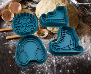 Winter-themed cookie cutters: snowflake, earmuffs, ice skate, and ski shape, perfect for holiday baking magic.