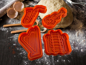 Musik-Keks-Ausstecher Set mit Saxophon, Geige, Harfe und Xylophon vor Teig auf Backtisch, kreative Backzubehör für Musikfans