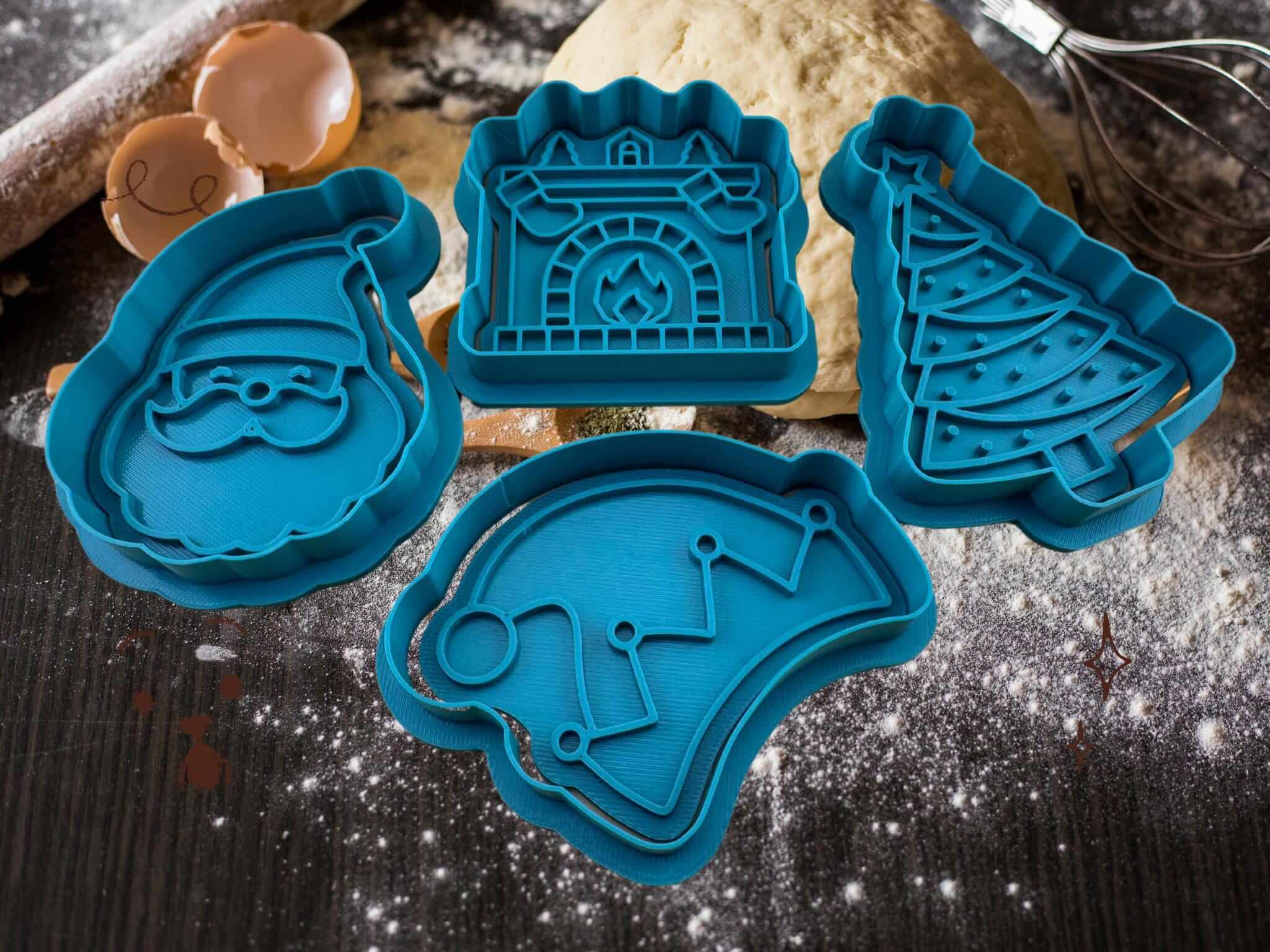 Set of blue Christmas cookie cutters: Santa, fireplace, tree, and hat on a floured surface.