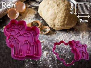 Pink reindeer cookie cutter with dough on a wooden surface, ideal for creative holiday baking.