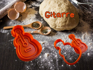 Musik Keks-Ausstecher in Gitarrenform auf einem Küchentisch mit Teig und Zutaten.