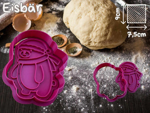 Pink polar bear cookie cutter with dough and baking ingredients, ideal for festive winter baking fun.