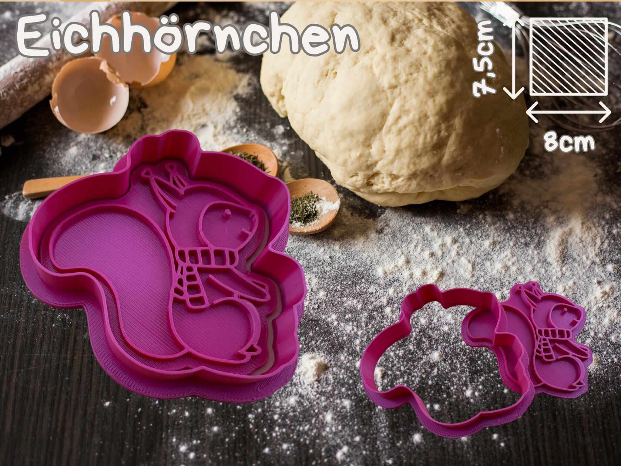 Purple squirrel cookie cutter for Weihnachtsbäckerei with dough and baking utensils in the background.
