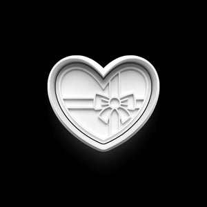 Heart-shaped cookie cutter with gift bow design, ideal for Valentine's Day baking and DIY projects.