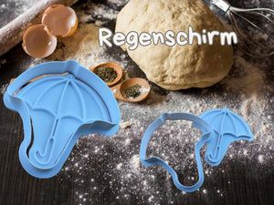 Herbstlicher Keks-Ausstecher in Form eines Regenschirms auf Teig, ideal für kreative Backprojekte.