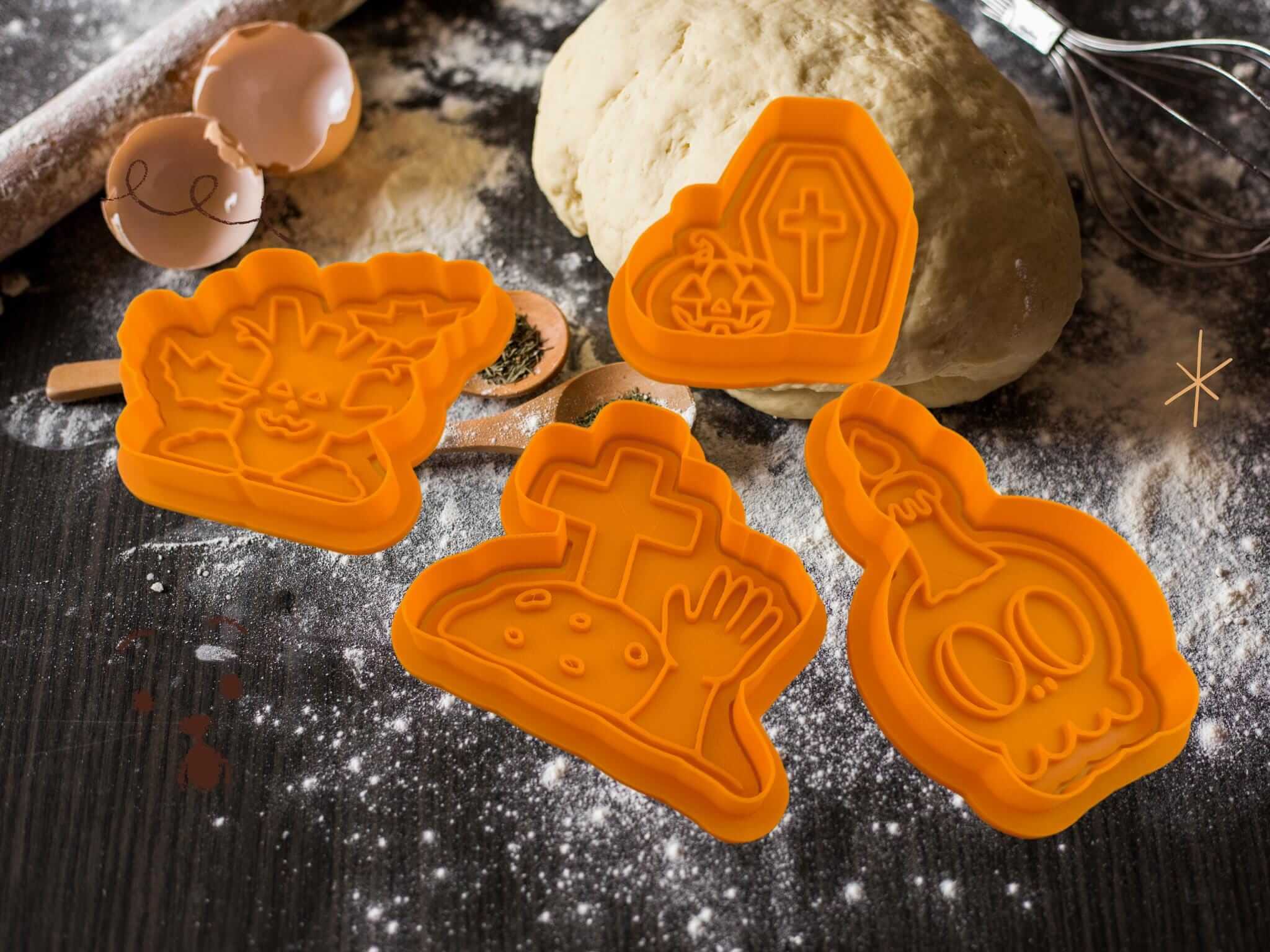 Spooky Halloween cookie cutters shaped as skull, tombstone, tree stump, and coffin, ideal for festive baking and decorations.