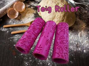 Three pink rolling pins with Christmas patterns on a baking table with dough and wooden utensils.