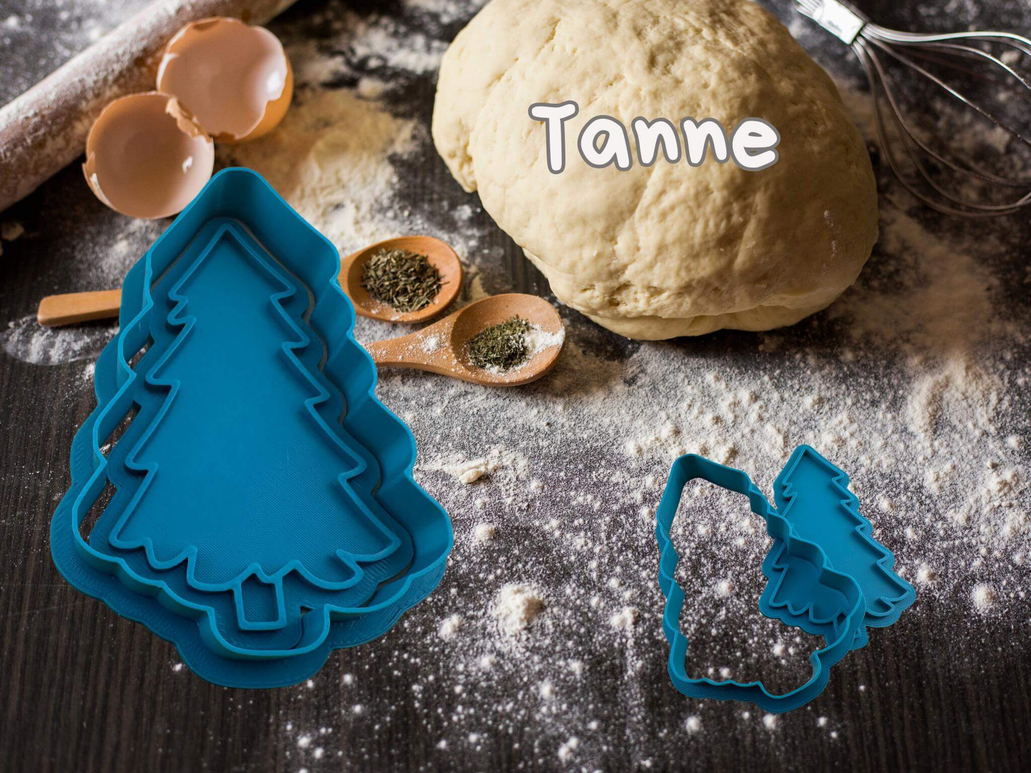 Blue Christmas tree cookie cutter set on a rustic baking scene with dough and spices, ideal for festive cookie making.