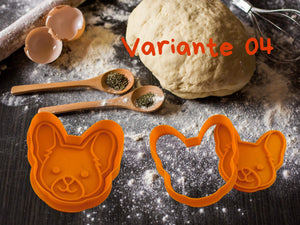 Oranger Hunde Keks-Ausstecher in Form eines Hundekopfes auf Mehl-Tisch mit Teig und Kochutensilien