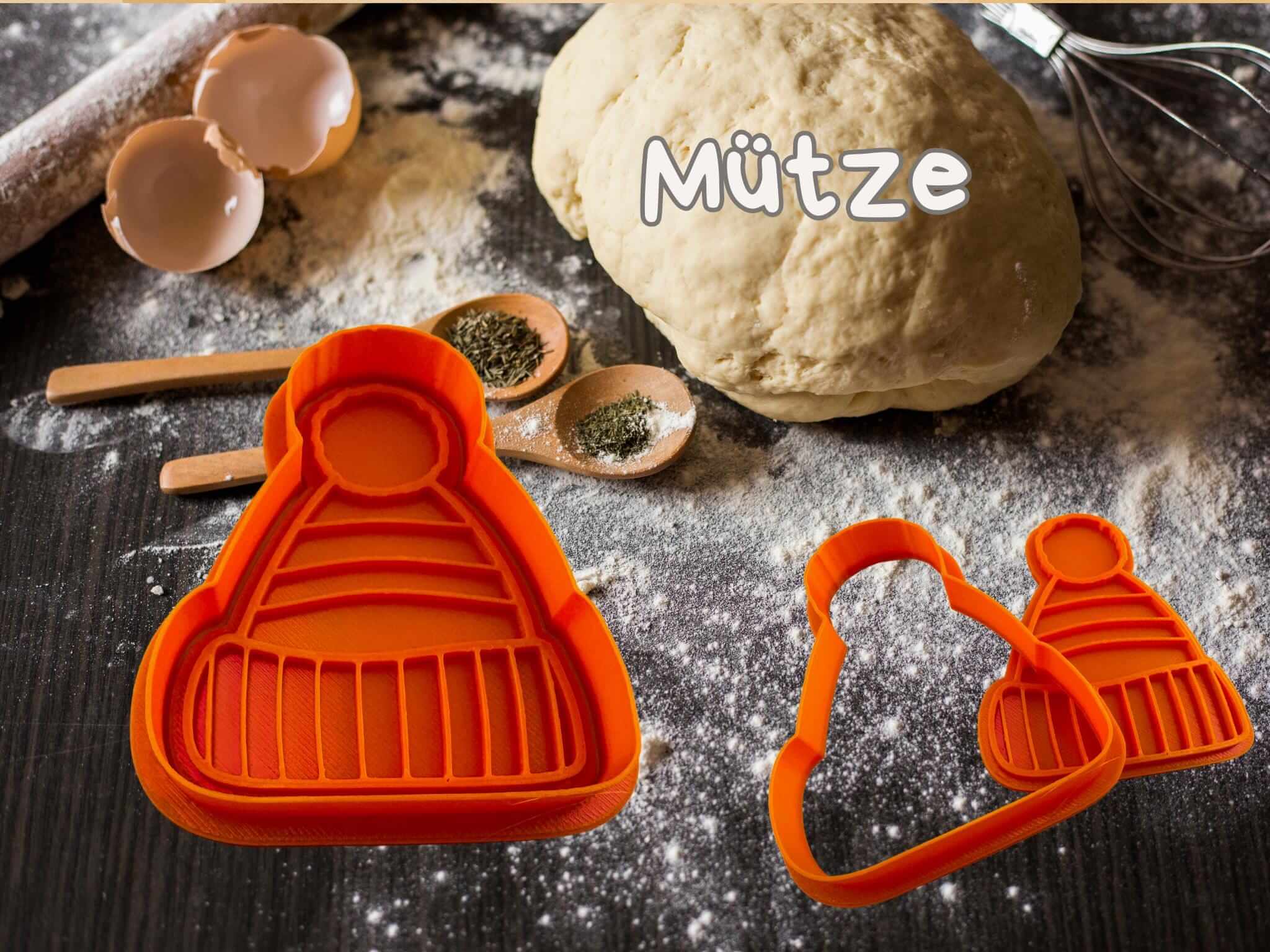 Wintermütze Keksausstecher auf Teig mit Küchenutensilien, ideal für festliche Weihnachtskekse.