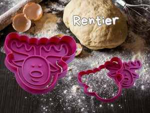 Purple reindeer cookie cutter next to dough and baking tools on a floured surface, perfect for festive holiday cookies.