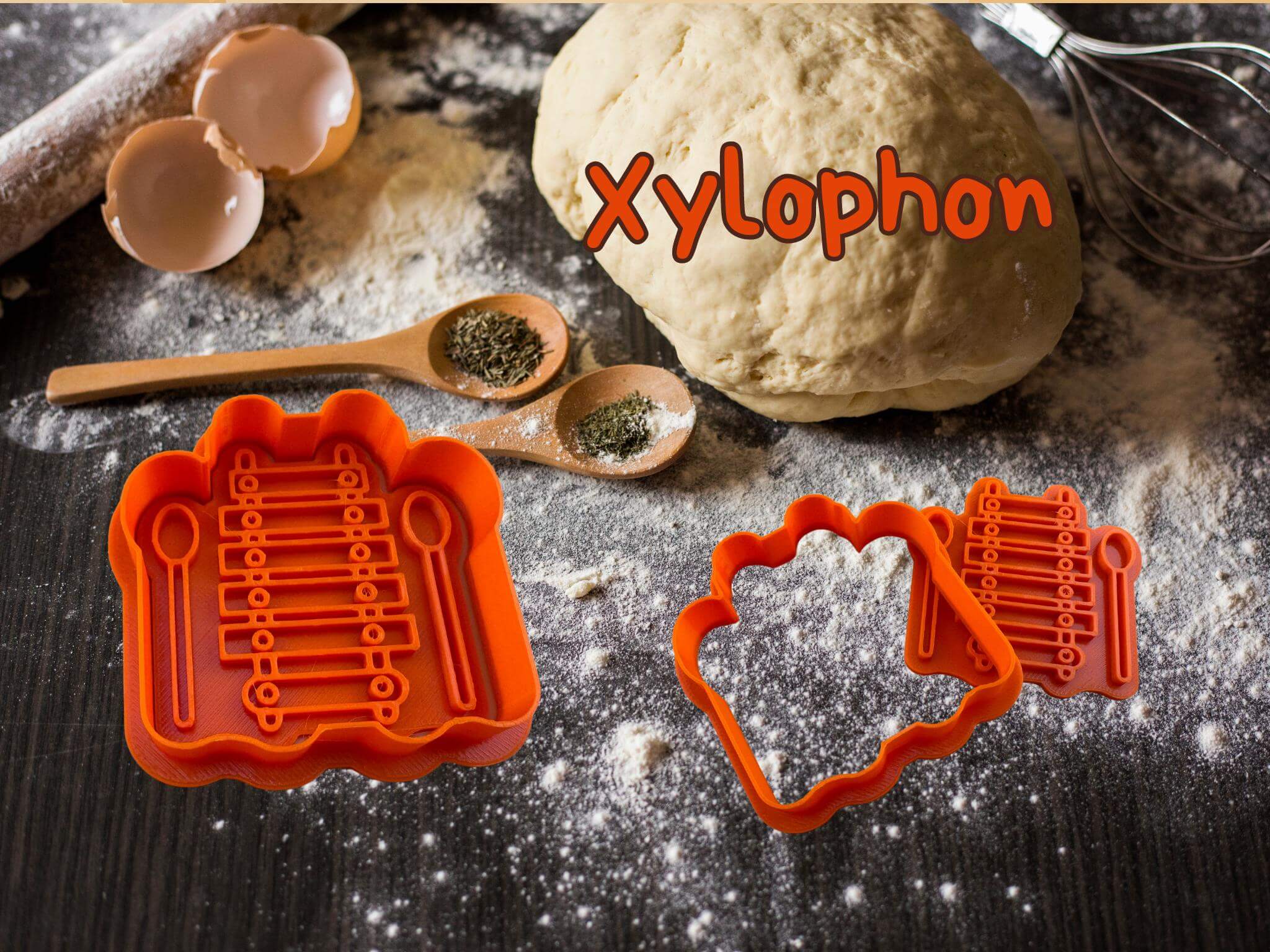 Musik Keks-Ausstecher Set für Xylophon, gezeigt auf bemehltem Backtisch mit Teig, Eierschalen und Gewürzen.