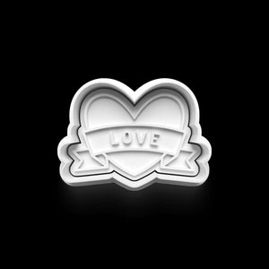 Heart-shaped cookie cutter with 'LOVE' banner for Valentine's Day baking.