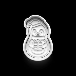 Pinguin Keks Ausstecher in Form eines niedlichen Pinguins mit Geschenk und Mütze auf schwarzem Hintergrund