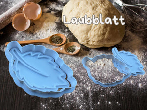 Blauer Laubblatt Keks-Ausstecher auf einer mit Mehl bestäubten Arbeitsfläche