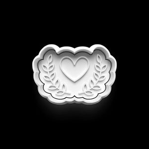 Heart-shaped Valentine cookie cutter with floral design on black background, perfect for romantic baking projects.