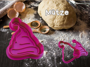 Weihnachtliche Keks-Ausstecher Mütze auf Teig mit Zutaten in einer festlichen Küchenszene.