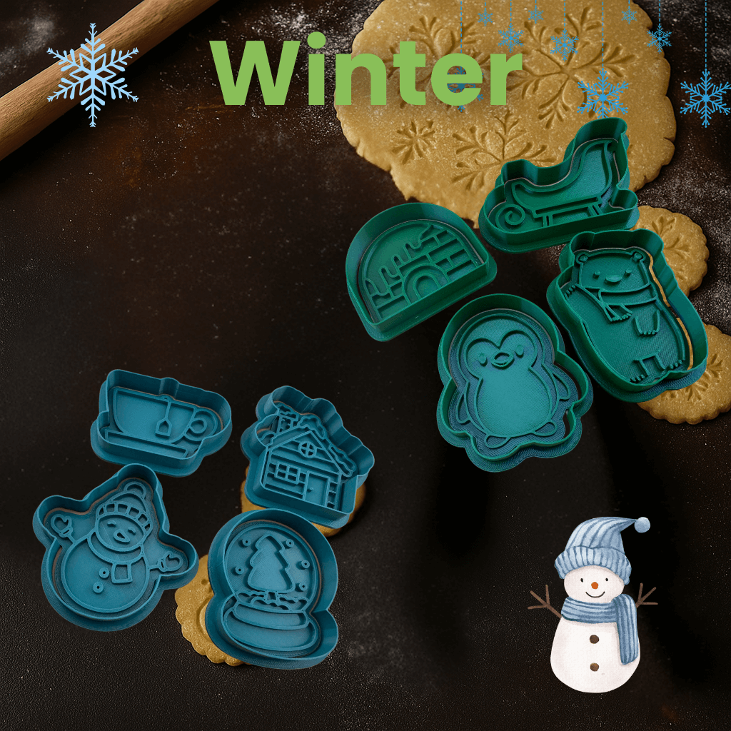Winter-themed cookie cutters featuring snowflakes, penguins, and winter animals on a baking surface with dough and a snowman.