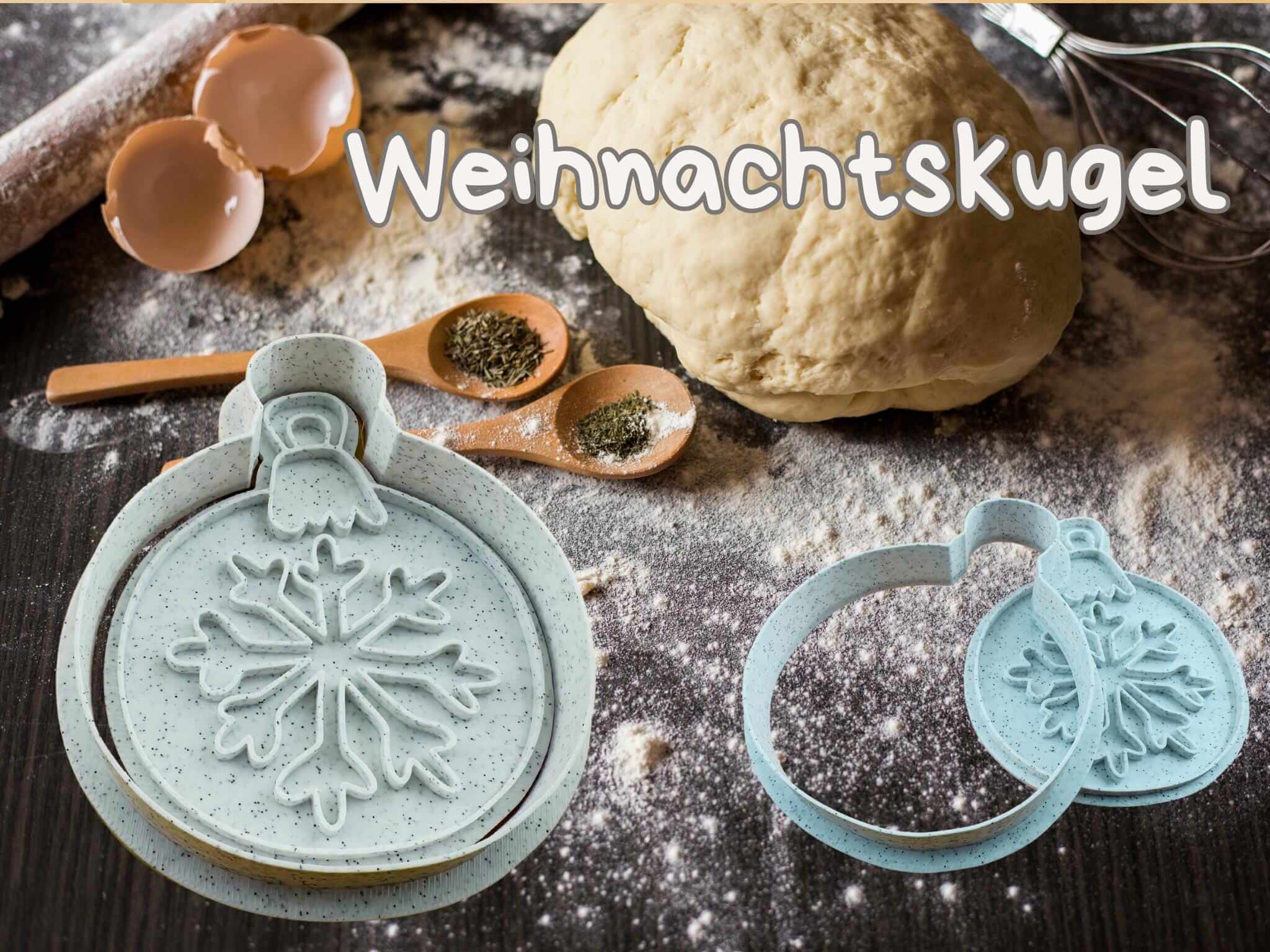 Weihnachtskugel Keks-Ausstecher Set auf einer mehlbestäubten Küchentheke mit Teig und Backutensilien.