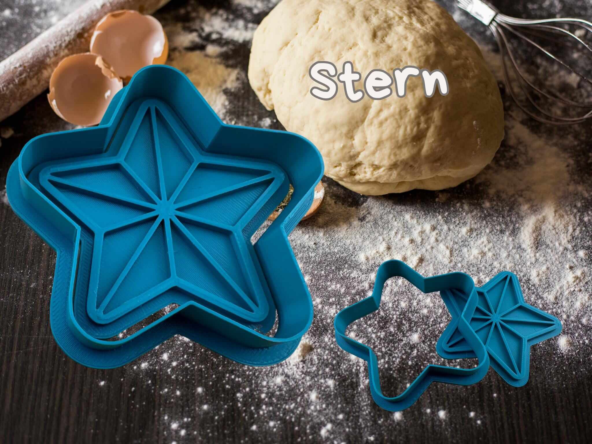 Blue star-shaped cookie cutters next to dough, perfect for creative Christmas baking with durable PETG plastic.